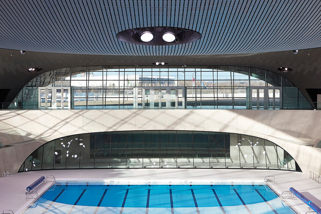 The undualting roof and the large glass façades of the water sports centre Aquatics centre really grab the attention.