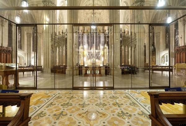 The double leaf glass swing doors in the lower section of the façade are set slightly further forwards in order to preserve the chapel’s original mosaic floor.