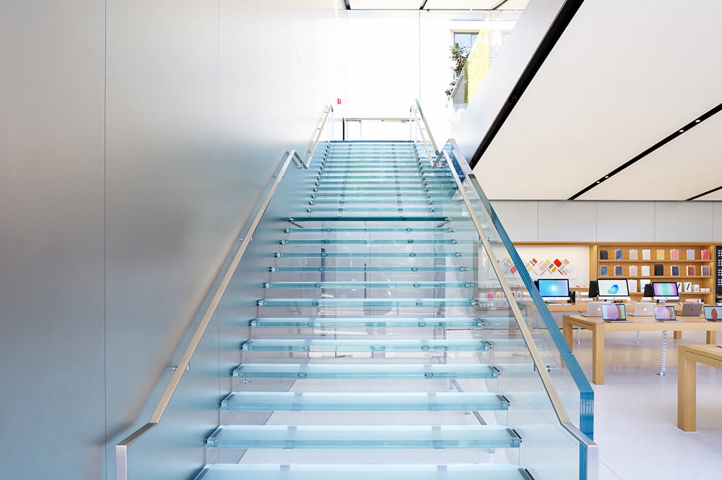 Two glass stairs lead to the upper floor of the Apple Store.