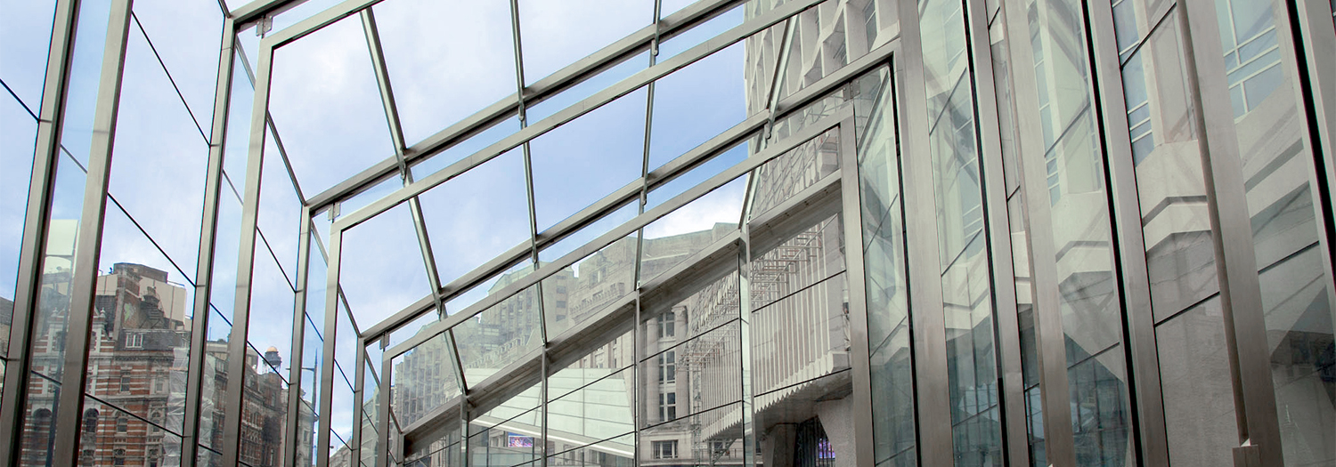 Tottenham Court Road Station - Plaza-Eingänge, London, UK: Der Stahl-Glas-Entwurf von seele ist ein futuristisches Glasgebäude mit Glassäulen, die bis zu 14 m in die Höhe ragen.
